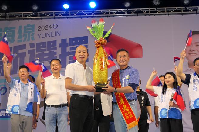 国民党徵召云林县海线立委参选人丁学忠（前右）5日在虎尾镇成立竞选总部，前高雄市长韩国瑜（前左）赠送「好彩头」，希望丁学忠前进立法院守护台湾和平。（张朝欣摄）