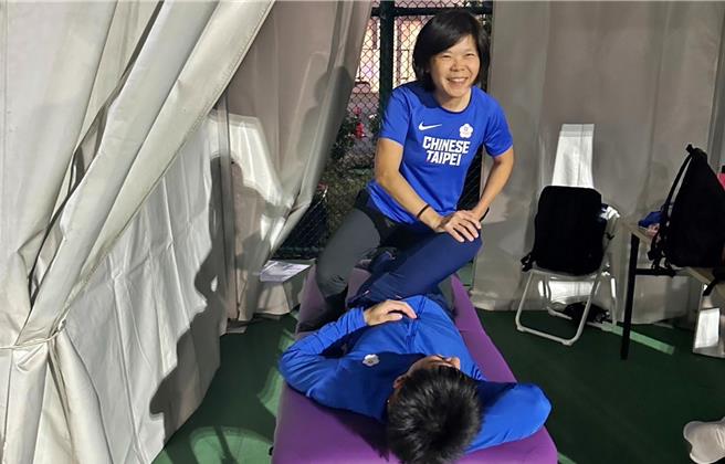 弘光科大老师李玮君(立者)为台湾最速男杨俊瀚(躺者)进行物理治疗。（张凯杰提供／陈淑娥台中传真）