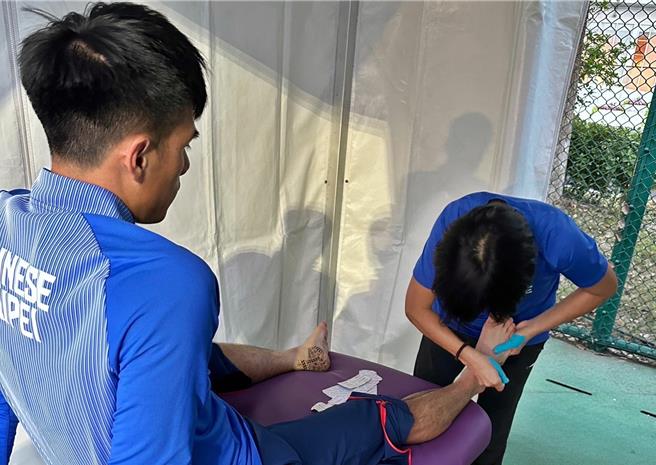 弘光科大老师李玮君(右)为台湾最速男杨俊瀚(左)进行物理治疗。（张凯杰提供／陈淑娥台中传真）