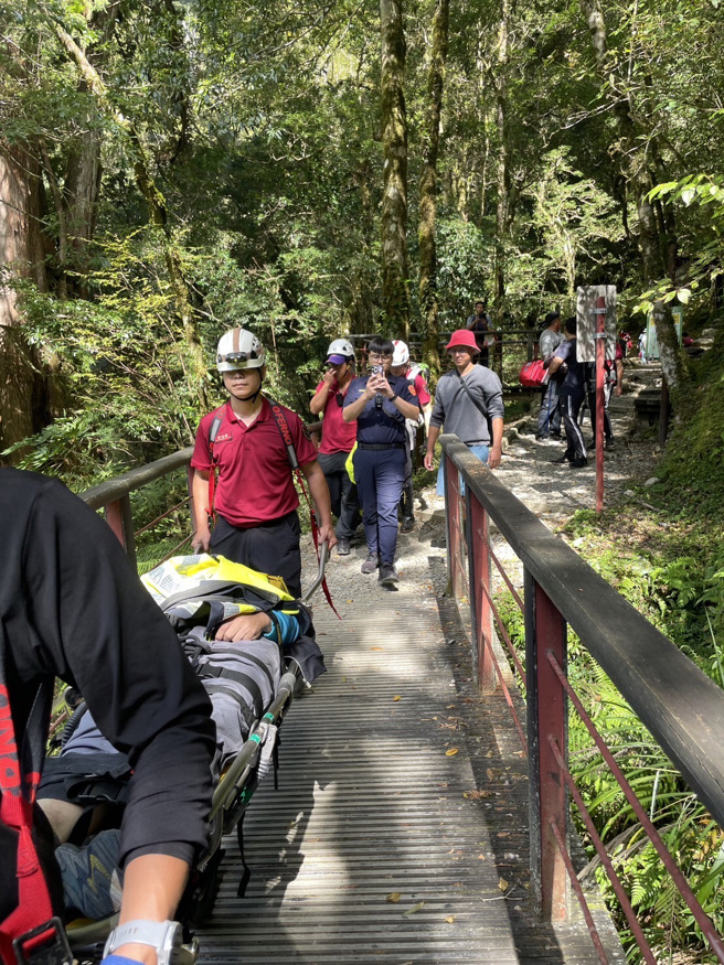 傷者68歲何姓男子，身體多處擦傷、頭部流血、意識清楚，救護人員給予清洗傷口、包紮止血並使用輪式擔架搬運下山。（圖／消防局提供）