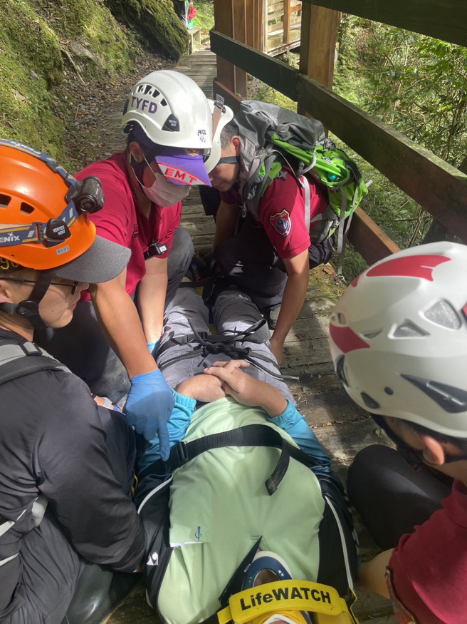 傷者68歲何姓男子，身體多處擦傷、頭部流血、意識清楚，救護人員給予清洗傷口、包紮止血並使用輪式擔架搬運下山。（圖／消防局提供）