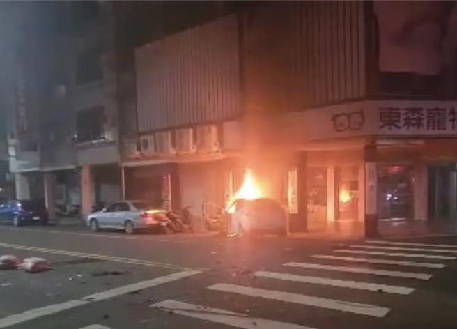 高雄一輛白色轎車闖紅燈撞上貨車，接著失控撞進路旁寵物店起火，所幸吳姓女駕駛自行逃脫僅受輕傷。（警方提供／任義宇高雄傳真）