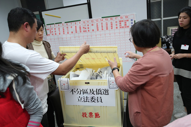 圖為選務人員打開政黨票的票匭準備唱票。（資料照,鄭任南攝）