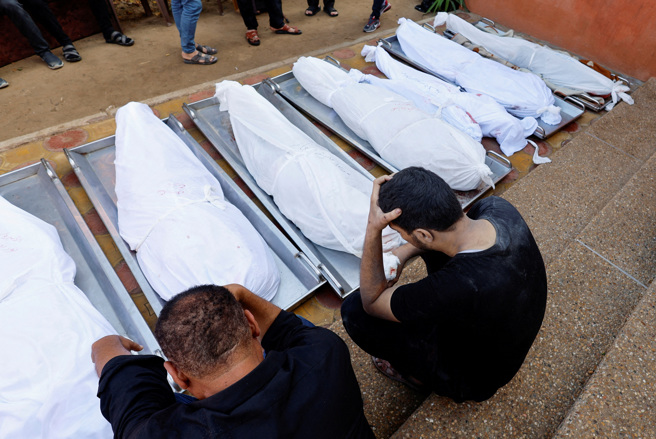 2023年11月7日，以色列空襲中喪生的巴勒斯坦人親屬在納賽爾醫院陪同。（路透社）