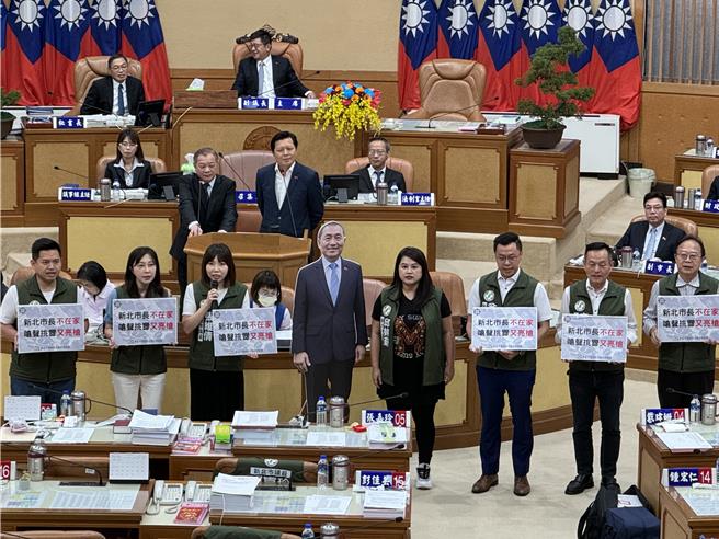 民进党团新北市议员今天针对治安议题进行总质询，持牌高喊「新北市长不在家，呛声挑衅又亮枪」。（柯毓庭摄）