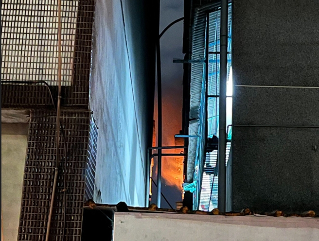 公寓後側窗戶，冒出明顯火煙。（翻攝畫面）