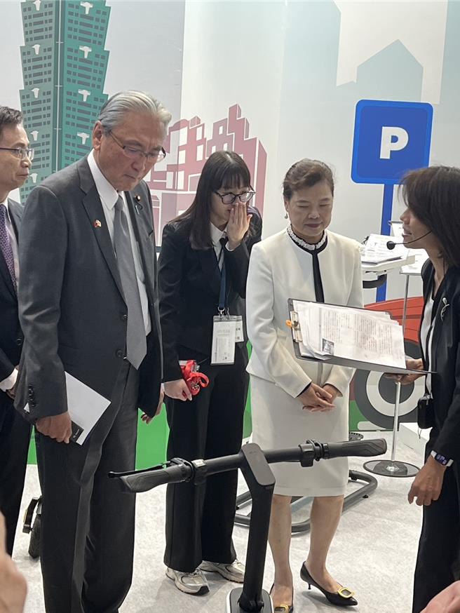 經濟部長王美花(右白衣者)率團訪日，今(9日)出席日本台灣形象展典禮，宣布成功招商4家半導體商來台投資擴廠。圖為她參觀會場台灣廠商介紹。(王玉攝)