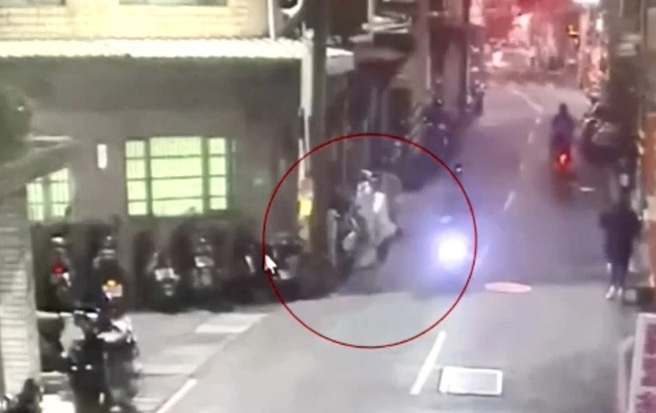 三重一名機車騎士於道路上正常行駛，行經車頭路一處時，忽遇當時於路邊行走的蘇姓男子，畫面可見蘇男為不明原因把腳抬起，作勢踹車。（圖 / 劉詠韻翻攝）