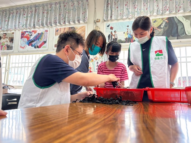 信义志工协助爱启儿学员进行垫圈代工作业。(图/信义房屋 提供)
