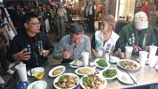 台灣民眾黨總統參選人柯文哲（右三）九日傍晚現身海安商圈，在滷味攤用餐時，一旁許多群眾圍觀。（程炳璋攝）