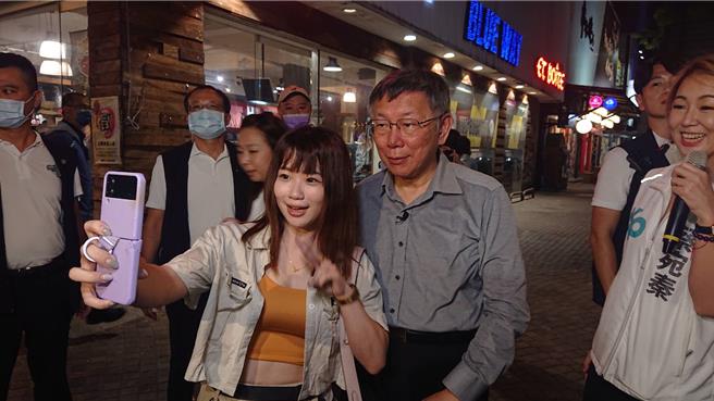 台湾民眾党总统参选人柯文哲（右二）九日傍晚现身海安商圈，吸引年轻人上前争相合影。（程炳璋摄）