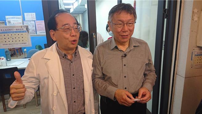 台灣民眾黨總統參選人柯文哲（右）九日傍晚現身海安商圈，一家婦產科診所院長張永隆（左）與他合影，熱情稱年輕患者都是柯文哲粉絲。（程炳璋攝）