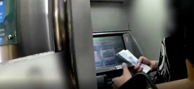 北市万华分局员警日前巡经辖内金融机构时，发现一名港籍人士持台湾金融卡不断提领大量现金。（图／翻摄画面）