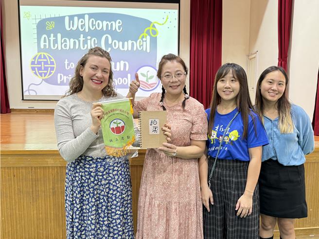 柏村國小校長許雪芳(左二)致贈紀念品與錦旗給大西洋智庫領隊Natalia Etten(左一)，歡迎他們前來關心金門的教育現況。(于家麒攝)