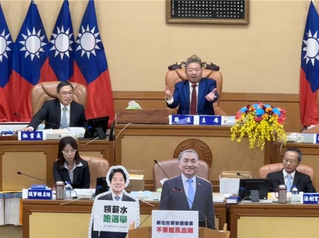 新北市议会国民党团、民进党团互相以两党参选人人形立牌「占领」质询台。（柯毓庭摄）