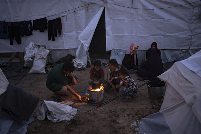 联合国在加萨走廊南部甘尤尼斯（Khan Younis）向流离失所巴勒斯坦难民提供帐棚栖身，难民生火煮食。（资料照／美联社）
