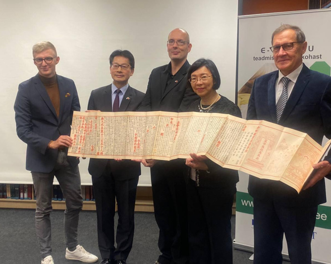 李宪章大使（左二）、爱国友台小组裴克多主席（左一）、爱国留台校友会会长李特（中）、曾馆长与塔林大学学术图书馆Kollist馆长共同展示古籍復刻图书《金刚般若波罗蜜经》。（爱沙尼亚代表处提供）