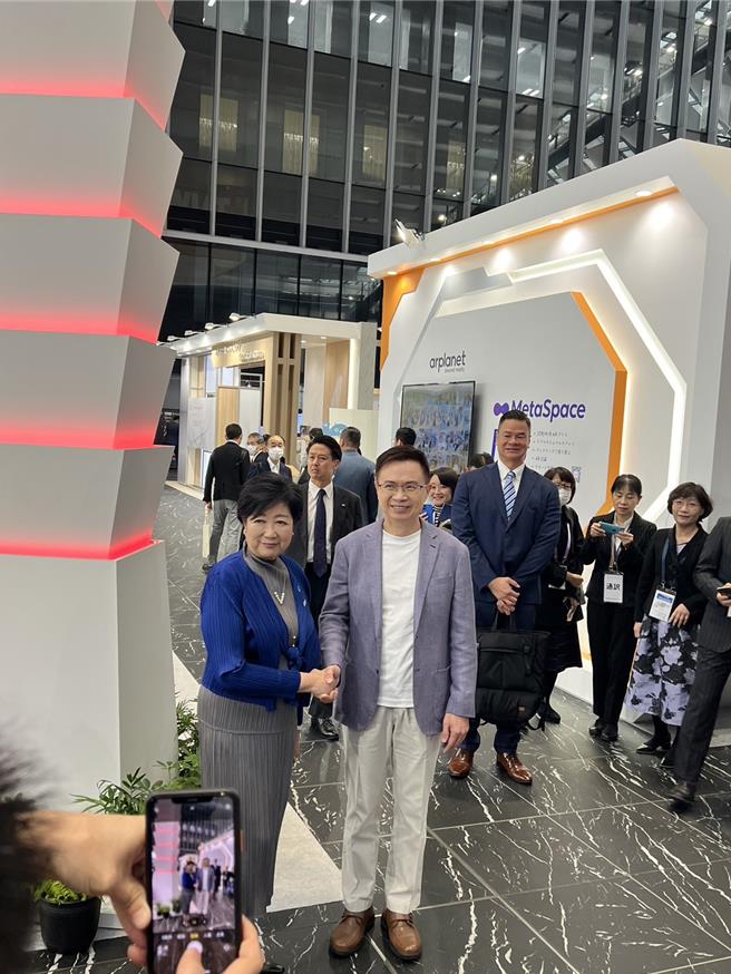 东京都知事小池百合子(左)今特地跑到日本台湾形象展参观体验，外贸协会董事长黄志芳亲自接待，双方在台湾地标101意象装饰前热烈握手。(王玉树摄)　