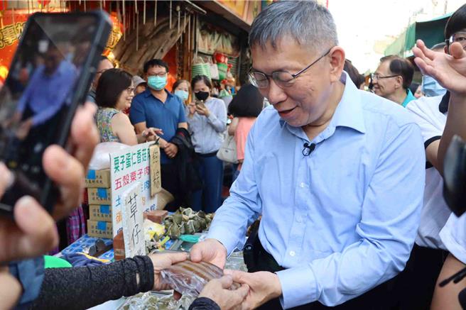 柯文哲11日上午参拜嘉义城隍庙后，前往嘉义市知名东市场扫街拜票，摊商反应两极。（吕妍庭摄）
