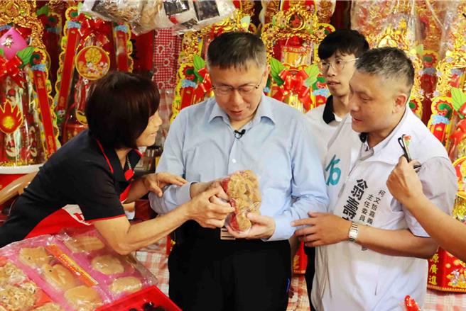 柯文哲11日上午参拜嘉义城隍庙后，前往嘉义市知名东市场扫街拜票，有商家送上发粿。（吕妍庭摄）