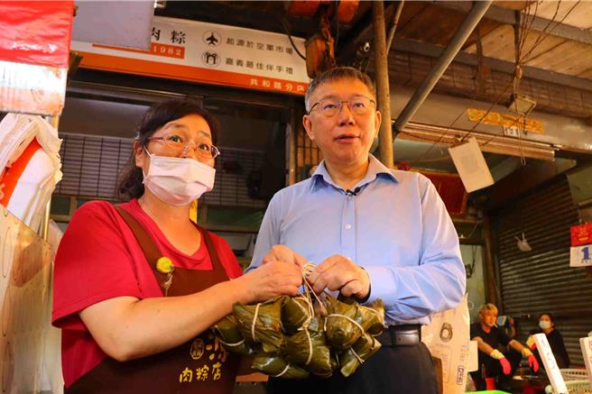 柯文哲11日上午参拜嘉义城隍庙后，前往嘉义市知名东市场扫街拜票，有商家送上粽子。（吕妍庭摄）