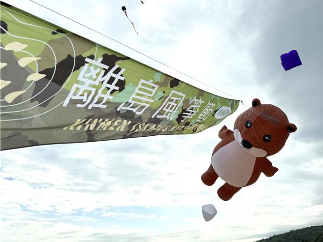 首次亮相的金门限定版巨型欧亚水獭风筝升起时，更萌翻现场民眾，纷纷拿出手机拍照打卡留念。(于家麒摄)