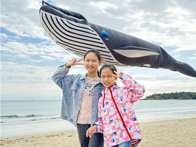 小朋友们看到自己喜爱造型的风筝升起时，竞相抢拍合照留念。(于家麒摄)