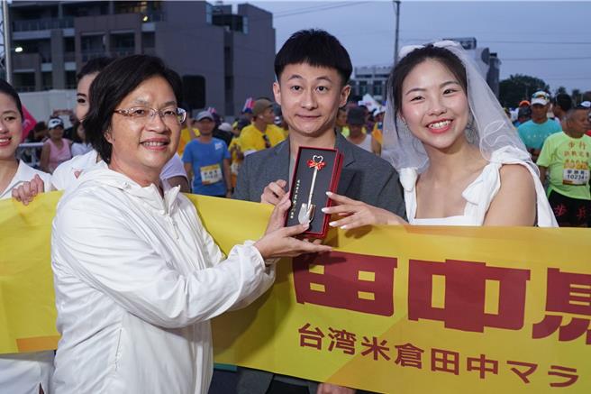 被誉为全台最有人情味的彰化田中米仓马拉松今日清晨6点开跑，因赛道结缘的新人在起跑线前，让县长王惠美（左）浪漫证婚。（吴建辉摄）