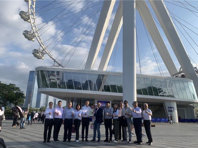 基隆市长谢国梁（左六）12日参访深圳市「欢乐港湾」最着名的地标「湾区之光」摩天轮。图为谢国梁抱着女儿小爱及副市长邱佩琳（左四）、督发处长谢孝昆（右五）、文化局长江亭玫（右四）以及贵宾合影。（徐佑升摄）