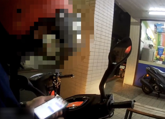 阮姓越籍移工机车违停超商门口，低头滑手机时遇警上前盘查。（图 / 刘咏韵翻摄）