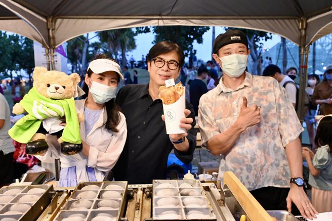 高雄市长陈其迈昨逛「城市屿浪市集」逛得不亦乐乎，除了大啖美食，也与摊车业者聊得十分开心。图为市长陈其迈与屿浪金奖「her呷鸡蛋糕」合影。（图／高雄市青年局）
