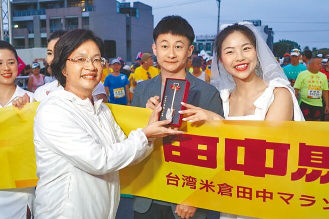 因賽道結緣的沈家志（中）、林芸萱（右）獲主辦單位邀請擔任領跑人，在彰化田中米倉馬拉松起跑線前讓縣長王惠美（左）浪漫證婚。（吳建輝攝）