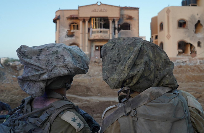 以色列国防军（IDF）上战场时，为了破坏头盔轮廓，让敌方难以辨识，都会在上面外罩有如厨师帽的「顶冠」（Mitznefet ），图为两名以军11月11日在加萨进行地面攻击的画面。（路透）