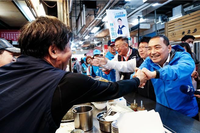 国民党总统参选人侯友宜14日到竹北市仁义市场扫街拜票，热情摊商和侯友宜握手喊「冻蒜！」（罗浚滨摄）