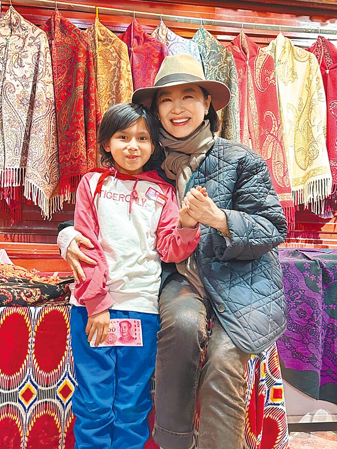 林青霞（右）在新疆与当地小朋友亲切互动。（林青霞提供）