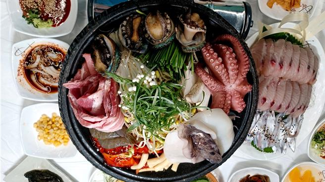 麗水「章魚三合」是將章魚、五花肉、芥菜辛奇搭配組合的料理，搭配活鮑魚、蔬菜等配料，海鮮陣仗超豪華。(陳韻萍攝)