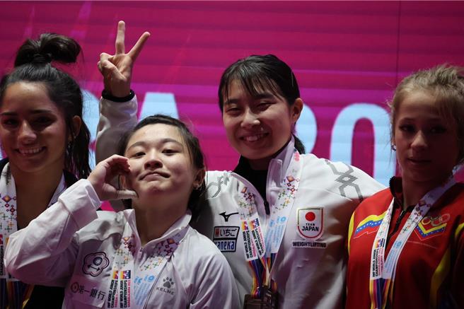 彰化县成功高中体育班学生黄宜甄（左二）16日在世界青年举重锦标赛女子49公斤级勇夺金牌，她开心与他国选手合照。（彰化县政府提供／孙英哲彰化传真）
