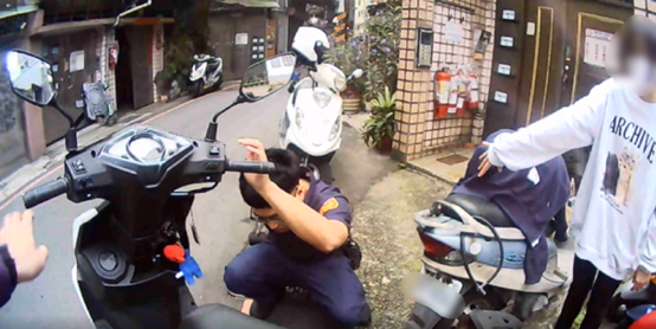 新北市1名女大生機車中柱卡在水溝蓋，使得她無法移動機車，無奈之下只好請求警方協助。（翻攝畫面）