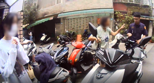 新北市1名女大生機車中柱卡在水溝蓋，使得她無法移動機車，無奈之下只好請求警方協助。（翻攝畫面）