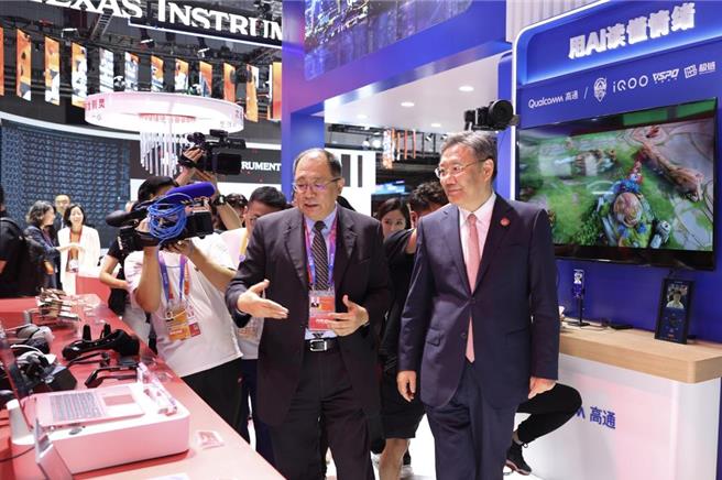 中国大陆商务部部长王文涛（前）在进博会期间，参观高通公司展台，并与企业交流。（中新社）