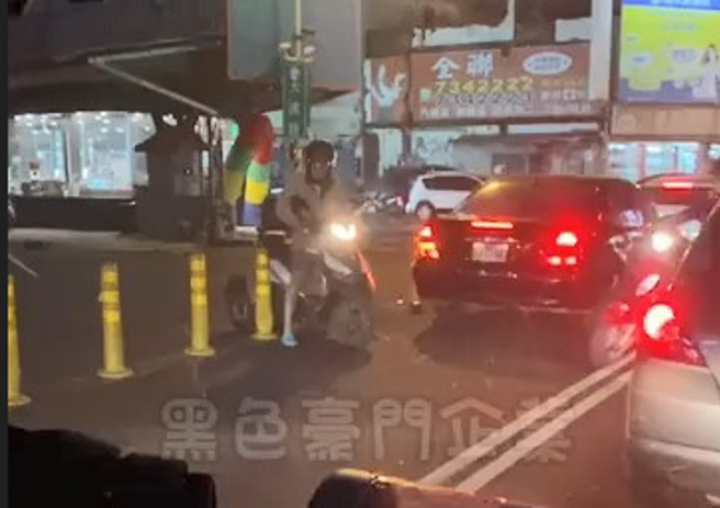 男子骑乘加装辅助轮的机车，穿越双黄线时，被防撞杆卡住。（翻摄黑色豪门企业）