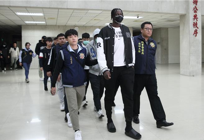 SBL職籃簽賭案持續延燒，士林地檢署17日擴大搜索、約談裕隆教練、球員、球團人員多人到案，其中外籍球員班霸（前排中）等人經刑事局訊問後，晚間送往士檢複訊。（張鎧乙攝）