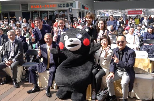 八代市于基隆举办熊本县物产展，自18日起一连两天在东岸广场登场。图为高人气的熊本县吉祥物「熊本熊」与基隆市议长童子玮（前排右一）、八代市长中村博生（前排左二）、议员郭美秀（二排右一）、议员陈宜（二排右二）、议员郑恺玲（二排右三）、议员秦钲（二排左二）合影。（基隆市政府提供／徐佑升基隆传真）