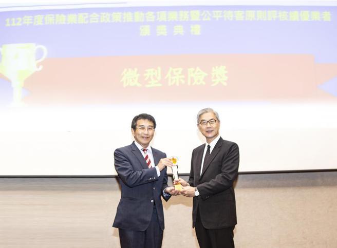 金管会主委黄天牧(左)颁发微型保险类保险辅助人组第一名奖座，由彰化银行副总经理陈斌(右)代表受奖。 图／彰化银行提供