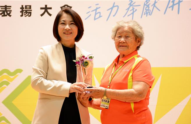 屏東縣2023年志願服務人員表揚19日於縣府大禮堂舉辦，高齡87歲的高柯新愛（右）從屏東縣長周春米手上接獲獎座，她開心笑說，好玩就好、非常歡喜。（林和生攝）
