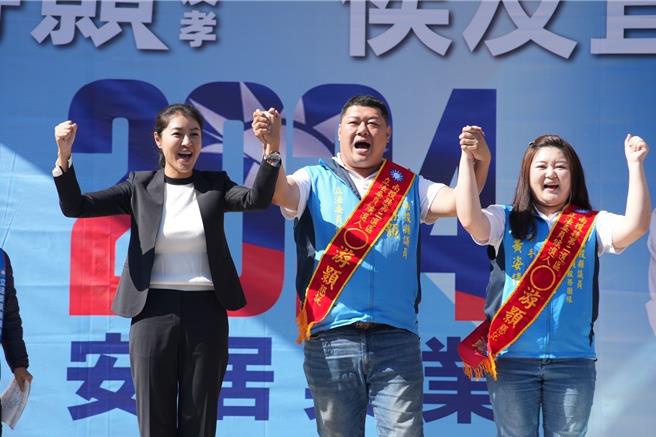 南投县长许淑华(左)19日在国民党南投二选区立委候选人游颢(中)水里竞总成立大会上，牵起游颢与游妻黄姿倩(右)的手带头喊「游颢冻蒜」！曾雪蒨摄