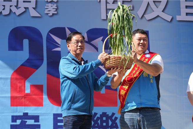 南投县前县长林明溱(左)送给游颢(右)一大盆青蒜，祝贺他冻蒜南投二选区立委帮他报仇。曾雪蒨摄