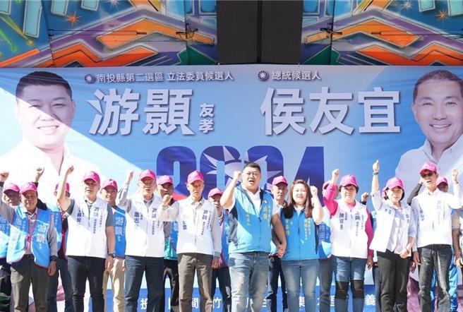 国民党南投县二选区立委候选人游颢(前排中)牵着妻子黄姿倩(前排右三)的手高呼「冻蒜」，誓言要把浊水溪线赢回来。曾雪蒨摄