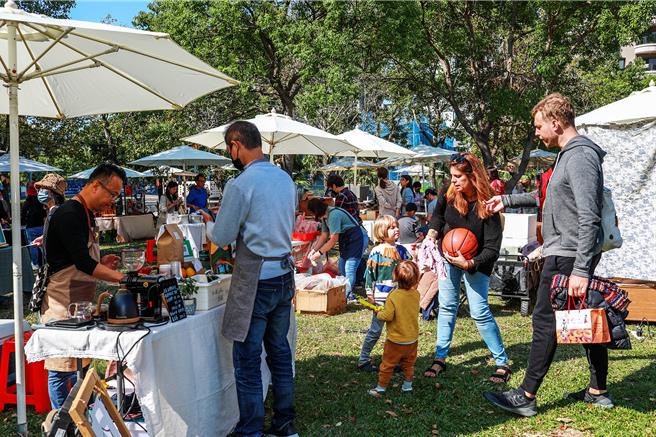 新竹县政府农业处19日在竹北水圳森林公园活动草坪举办「第三届农村藏食节」，有桃竹竹苗70个农特产品摊位，吸引外国亲子选购体验。（罗浚滨摄）
