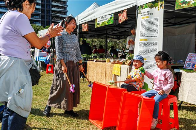 新竹县政府农业处19日在竹北水圳森林公园活动草坪举办「第三届农村藏食节」，小朋友在南埔社区摊位验体「咸菜桶打击乐」。（罗浚滨摄）